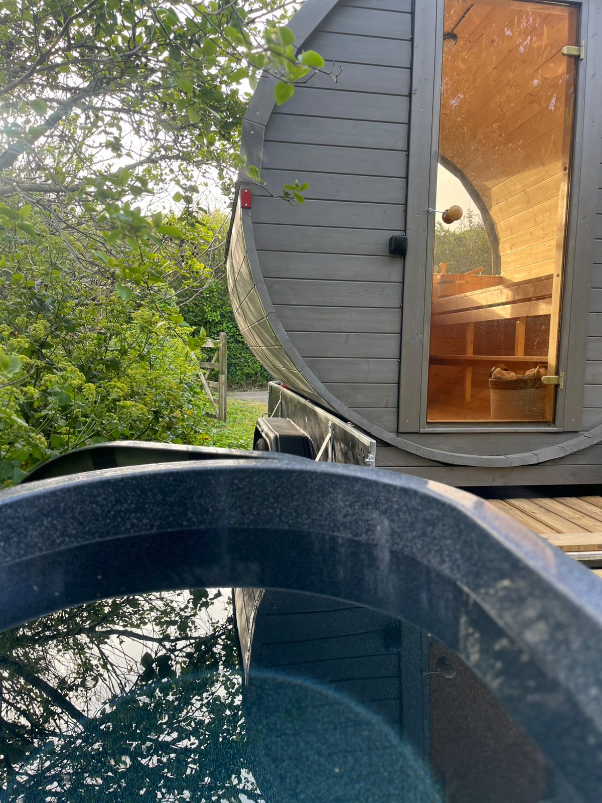 Terra Sauna mobile barrel sauna and cold plunge tub hire in a garden setting in Guernsey