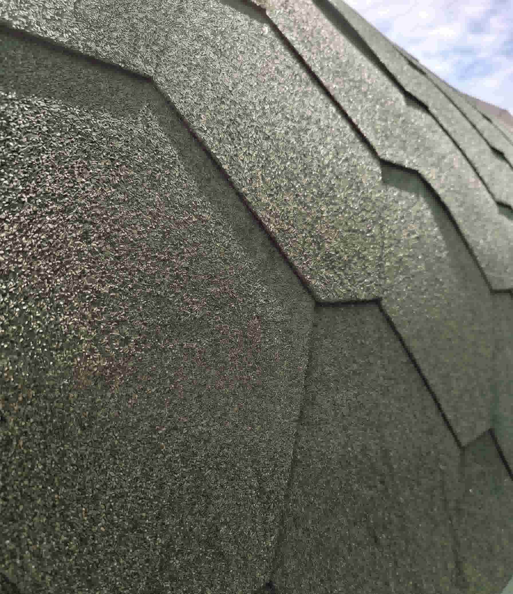 Close-up detail of dark green bitumen roofing shingles on an outdoor barrel sauna by Terra Sauna in Guernsey, showcasing the protective textured mineral granules and distinctive hexagonal design.